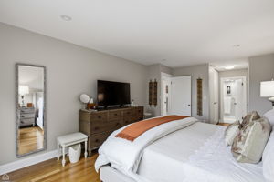Spacious primary en-suite bedroom offers a private hallway leading to a serene full bath