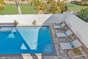 The rear deck offers a picturesque view of the spacious, inviting pool area ...