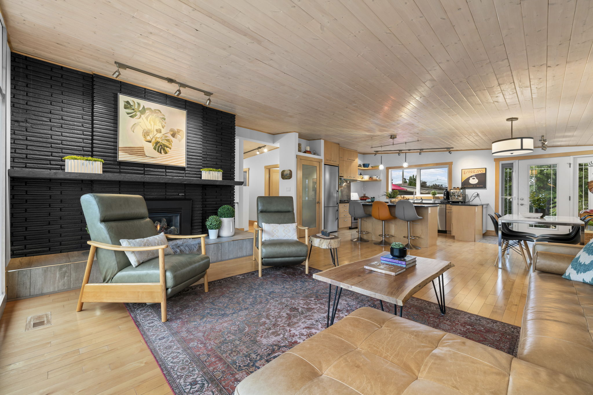Living room looking from the dark fireplace and green seating toward the dining area.