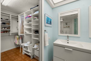 Primary bedroom walk-in closet features custom built-ins
