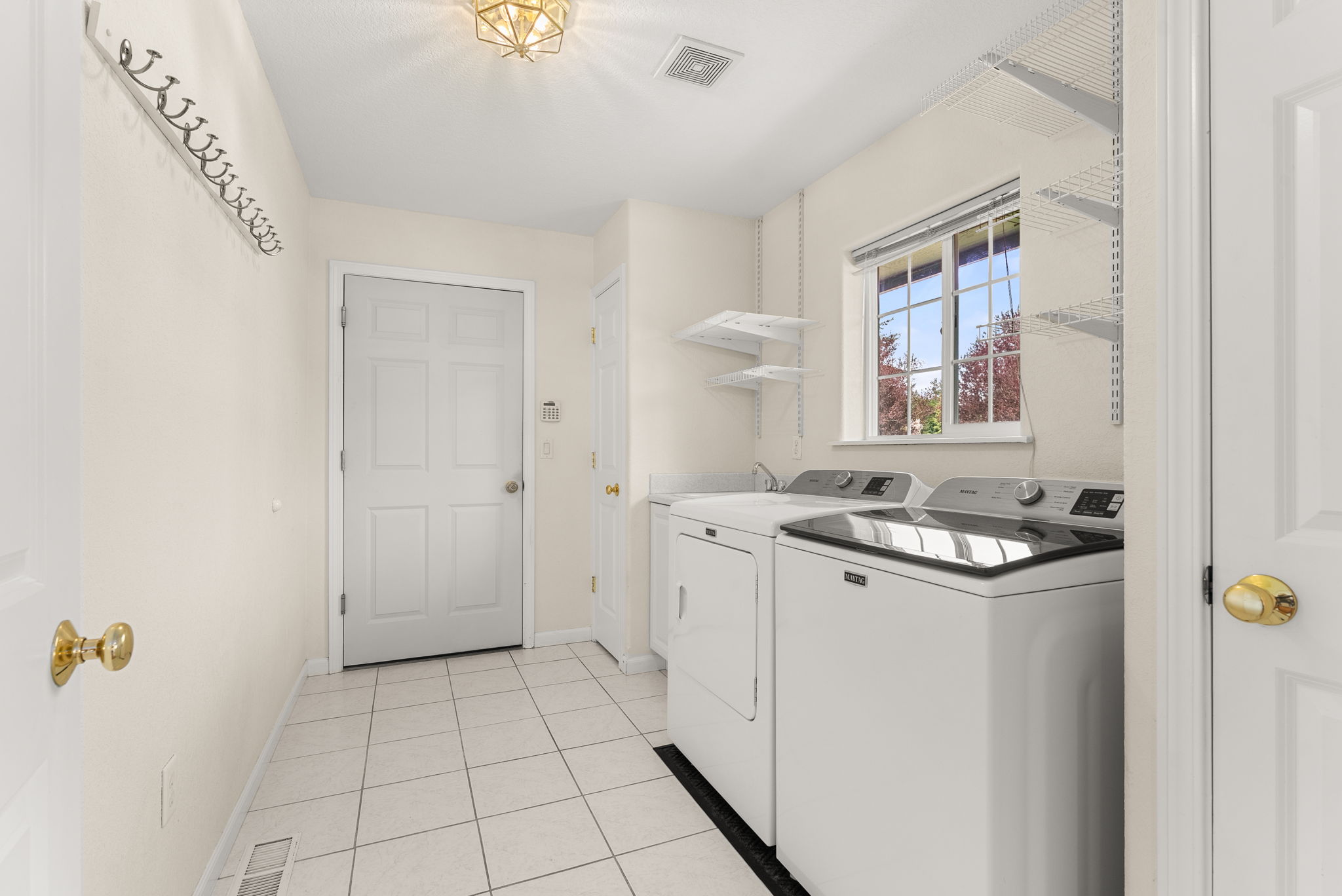 Spacious laundry room off the kitchen with window overlooking the front yard