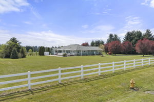Charming white fence lines the front, creating a warm and inviting entrance
