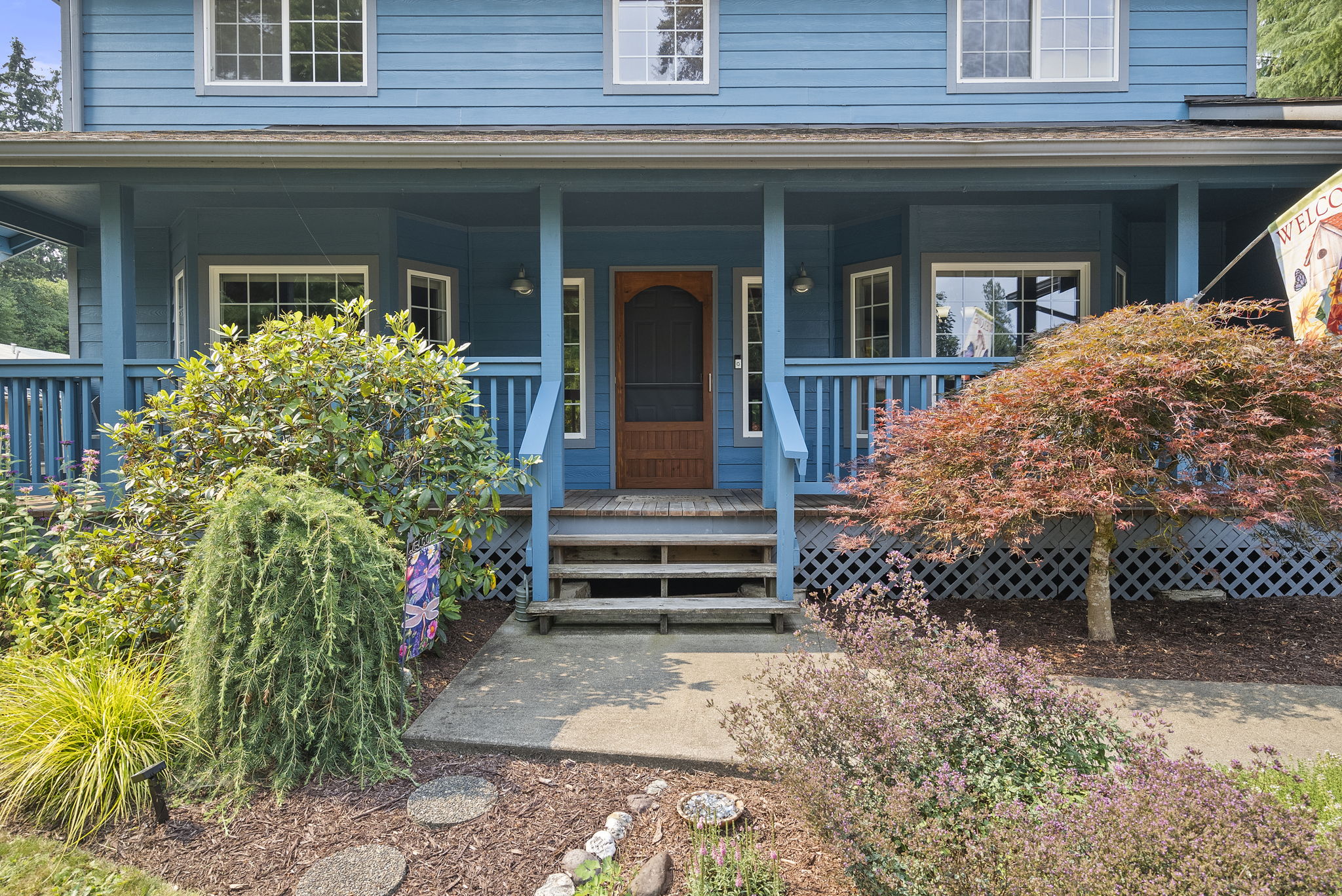 A classic covered porch, colorful perennial gardens, and thoughtful landscaping welcome you home.