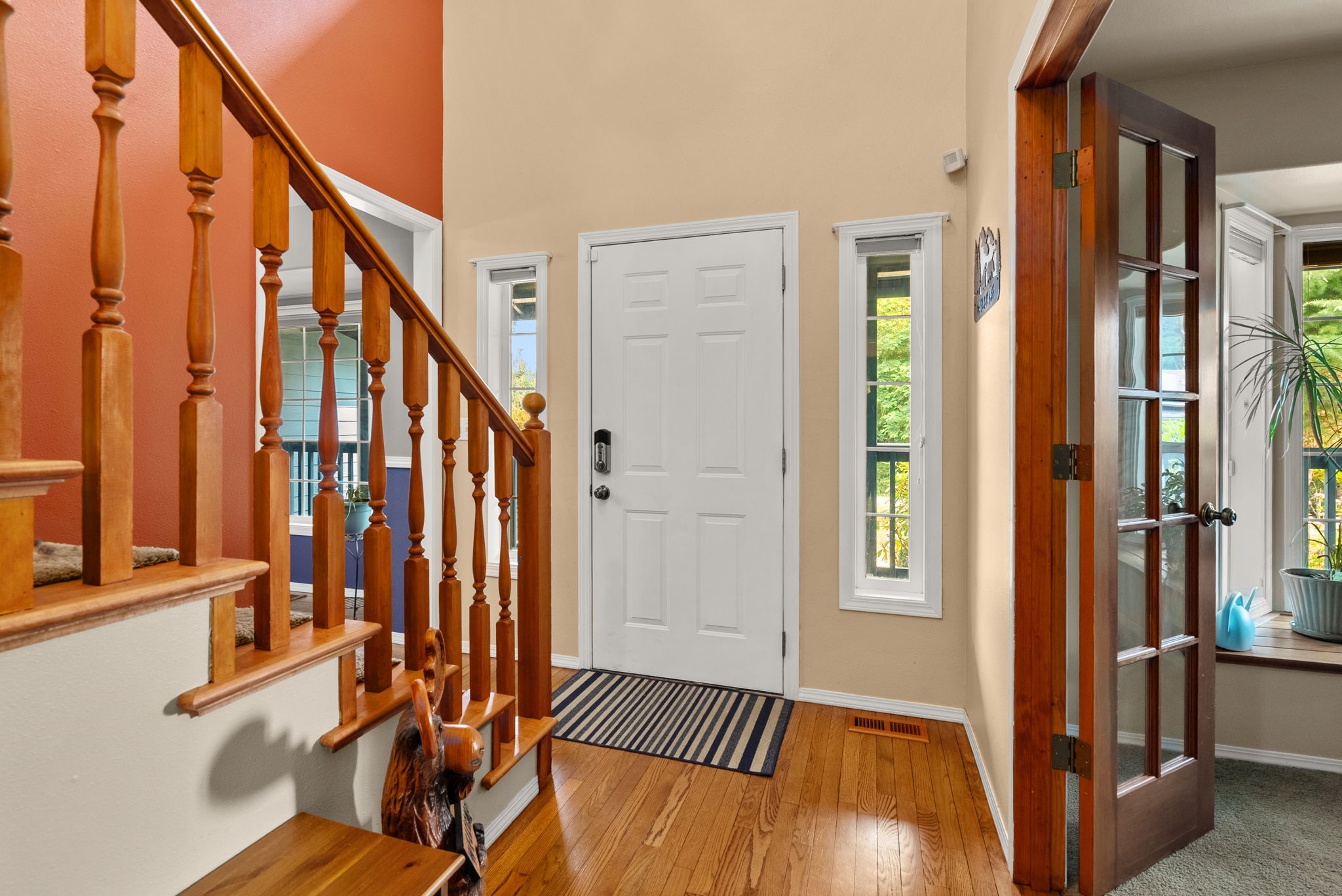 Welcoming two-story entry with soaring ceilings, hardwood floors, and an open staircase that creates an inviting first impression.
