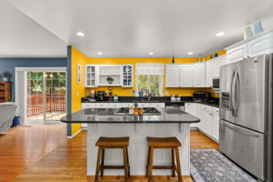 Spacious kitchen featuring granite countertops, stainless steel appliances, generous cabinetry, and a large center island with seating.