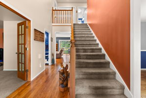 Vaulted ceilings, hardwood floors, and abundant natural light create an impressive entrance.