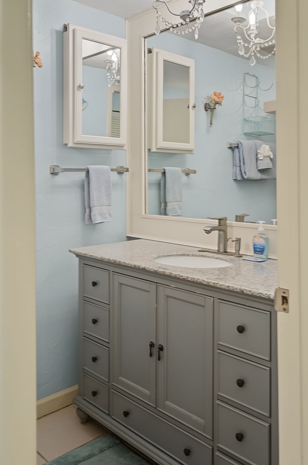 The bathroom is lovely and has a chandelier above the vanity.