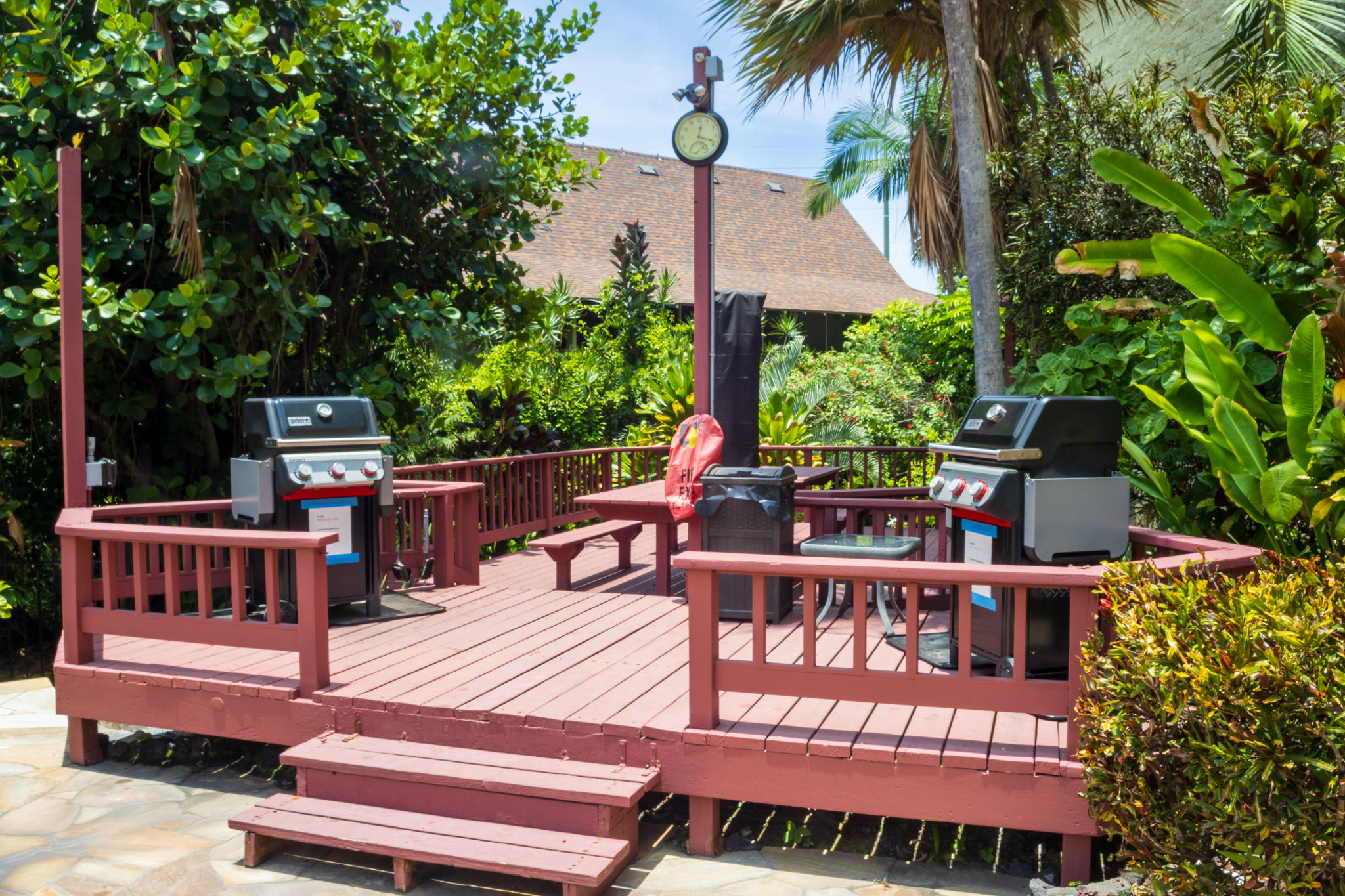 Picnic tables on BBQ deck next to pool.