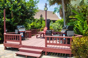 Picnic tables on BBQ deck next to pool.