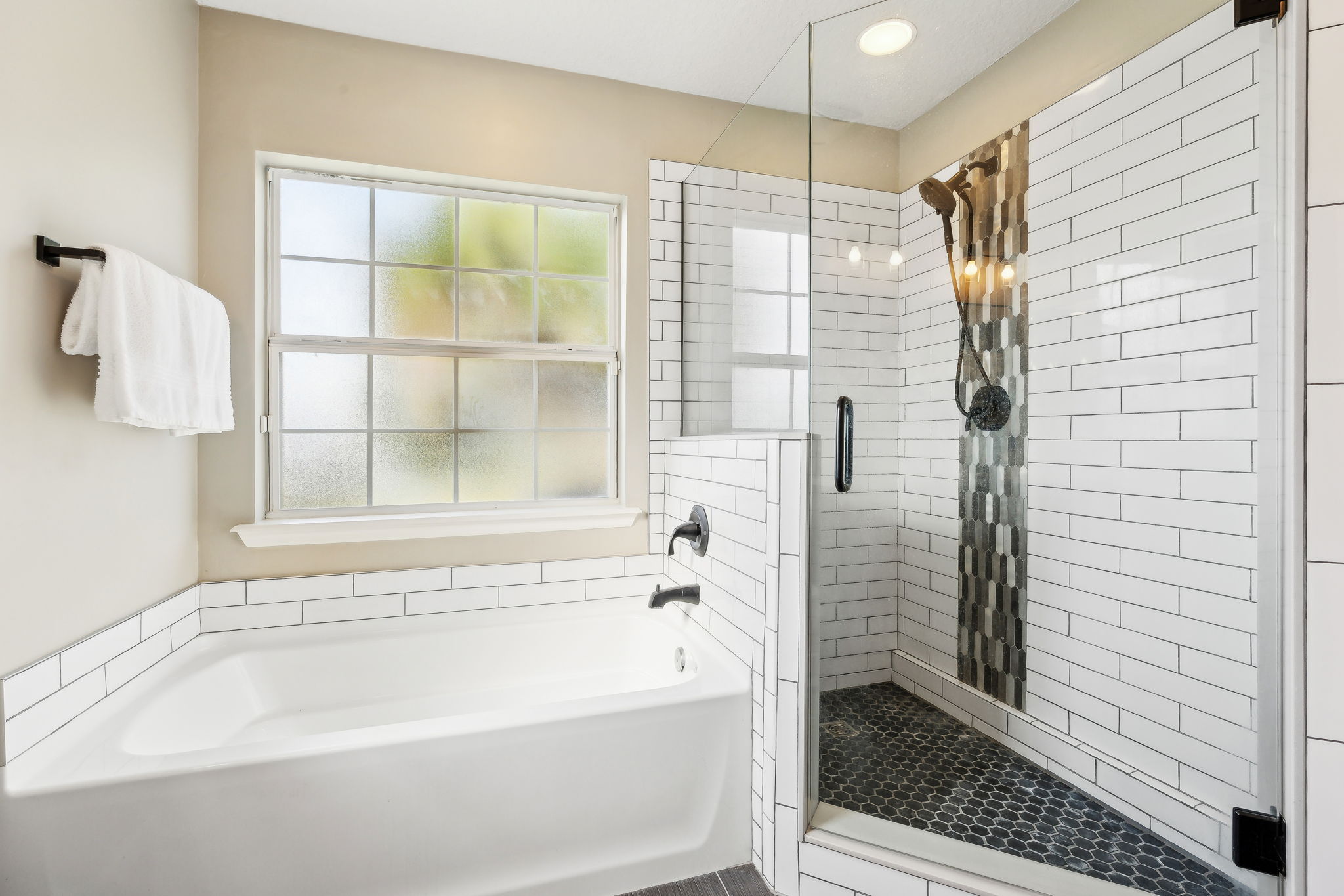 ... a soaking tub and a stylish tiled shower with frameless door