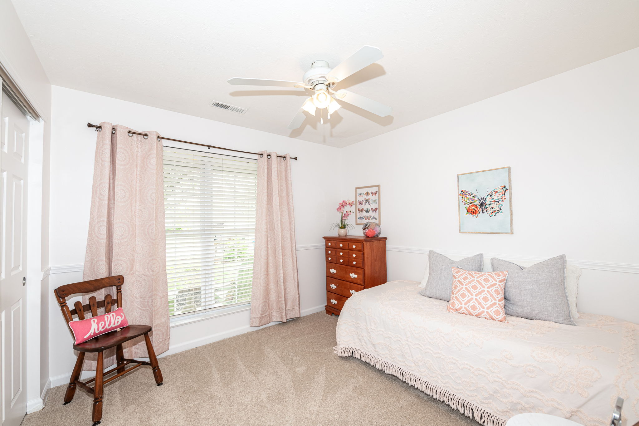 Front bedroom with double window overlooks front porch. Overhead lighting provided by ceiling fan with light kit.