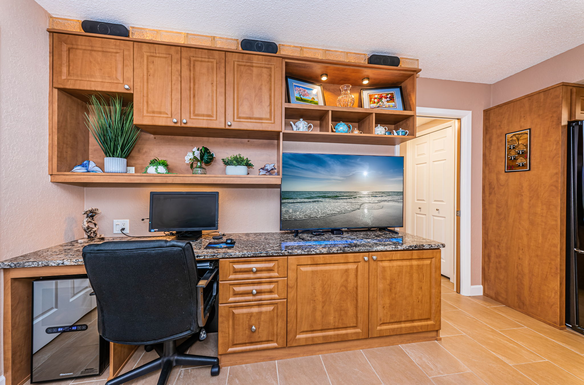 Built in matching kitchen cabinetry houses a Wine Cooler, Work Area and Entertainment Center! (Wine Cooler and Speaker System convey.)