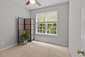 Main floor bedroom 1 overlooks wooded backyard