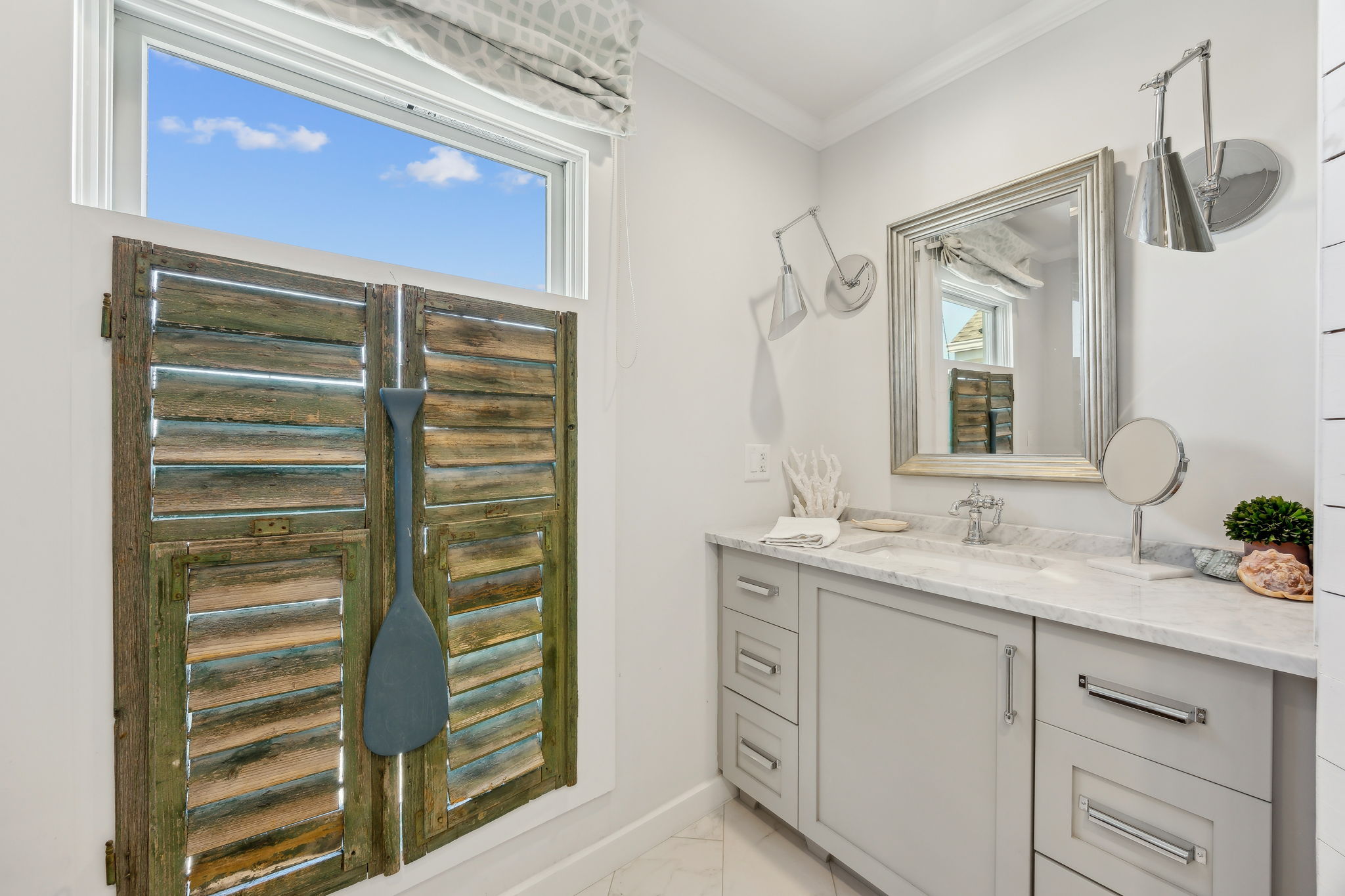 ...balanced by vintage shutters, thoughtful lighting, and a collected beach-house feel.