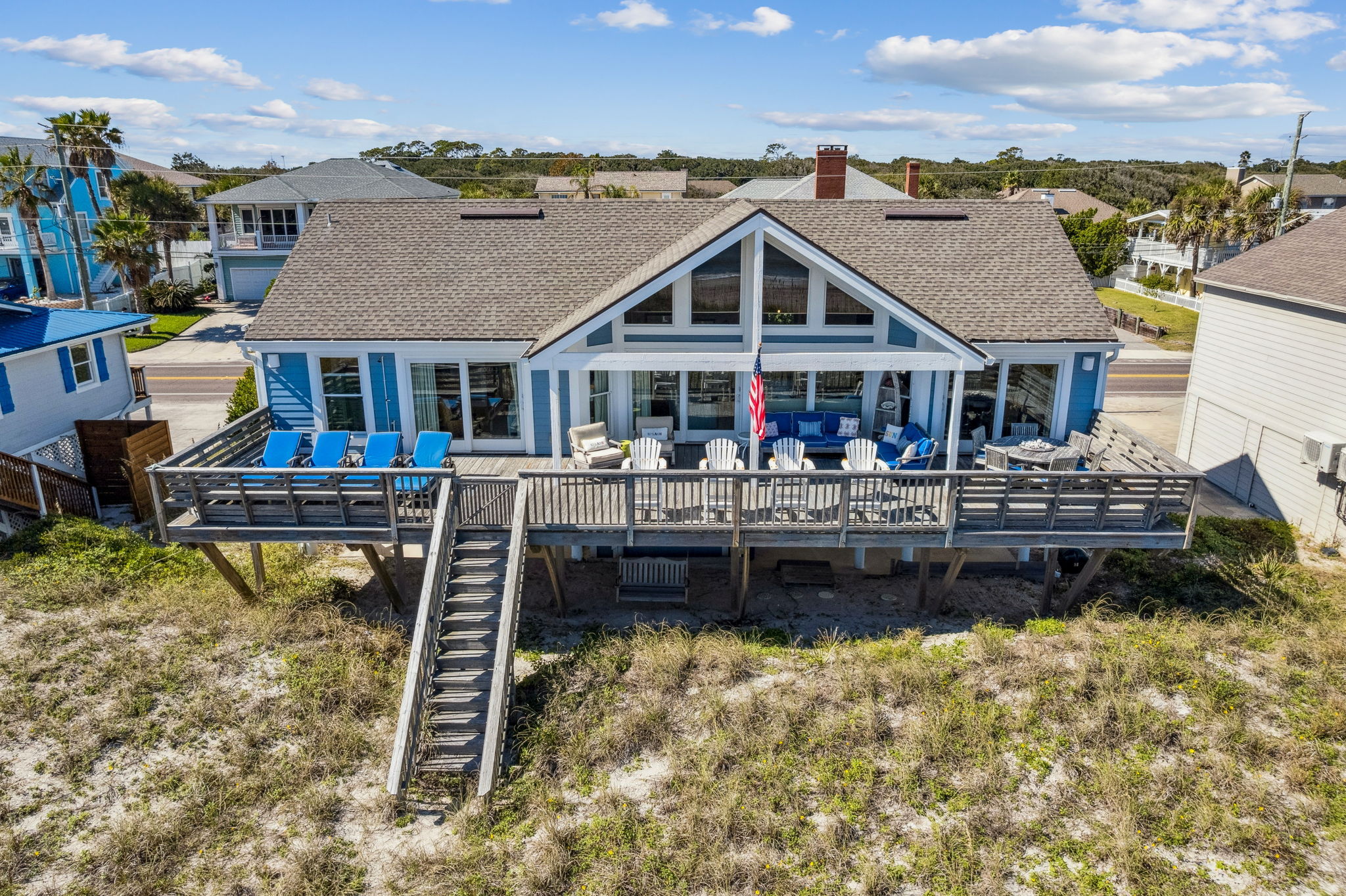 The full-width oceanfront deck anchors the home to the shoreline, creating outdoor living on a rare scale.