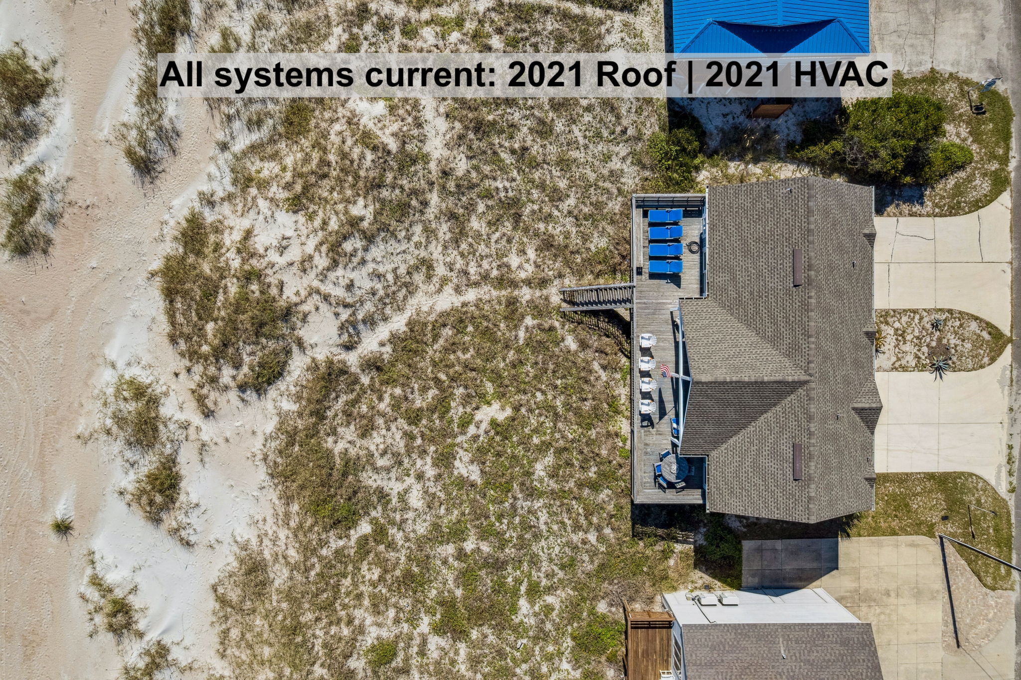 From above, the setting tells the story — ocean, dunes, deck, and home all connected without interruption.