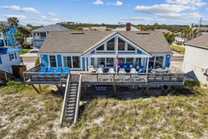 The full-width oceanfront deck anchors the home to the shoreline, creating outdoor living on a rare scale.