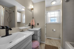 Newly remodeled primary en suite with new tile floors, vanity and lighting.