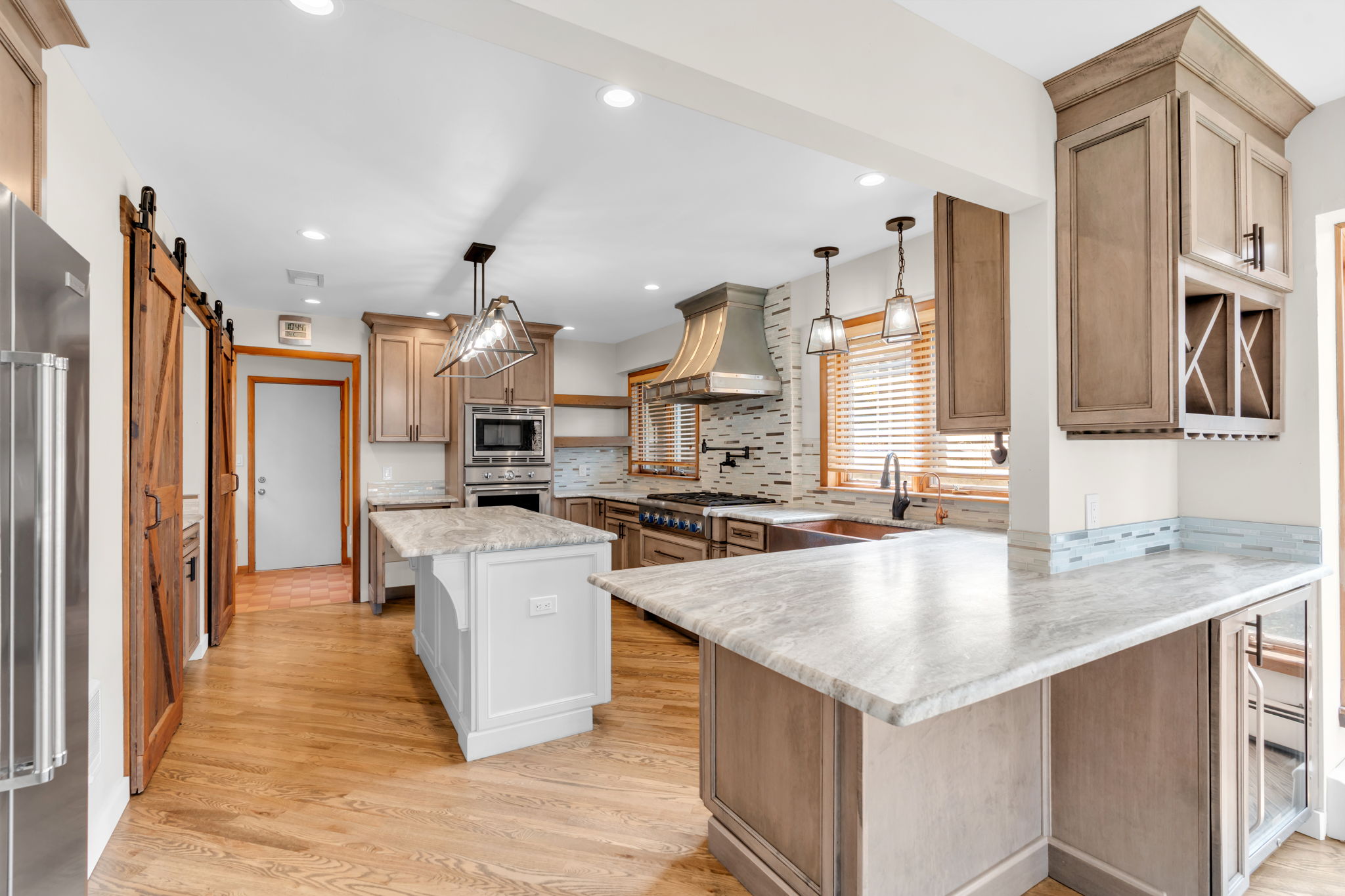 Spacious Kitchen with custom cabinetry. Breakfast bar, with dry bar and mini fridge, leather granite counter tops
