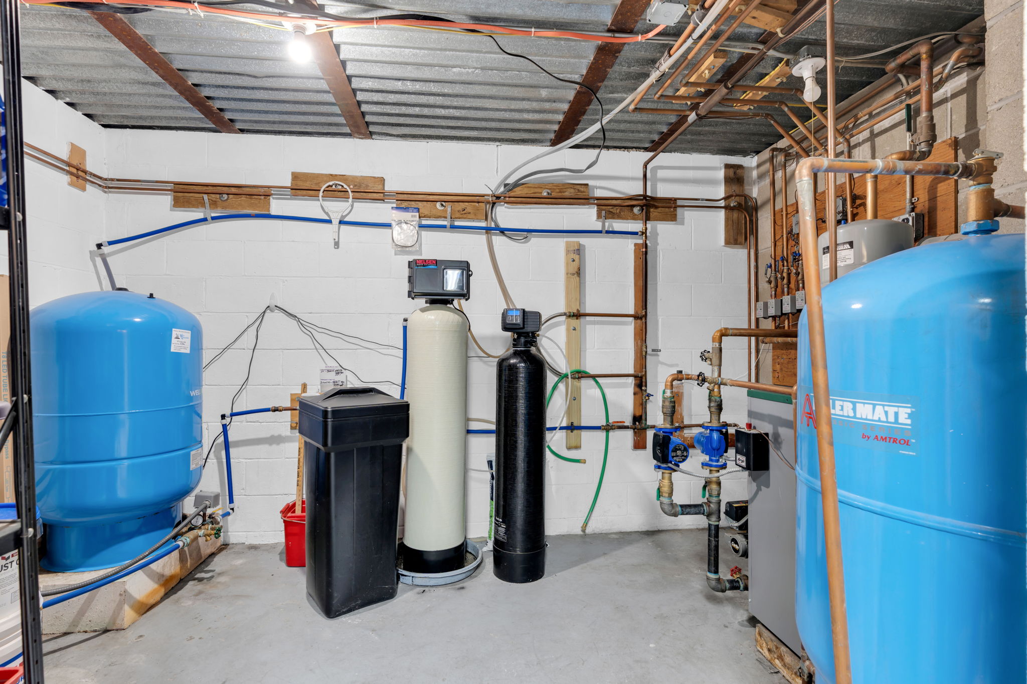 Utility room with newer well pump, boiler and water system.