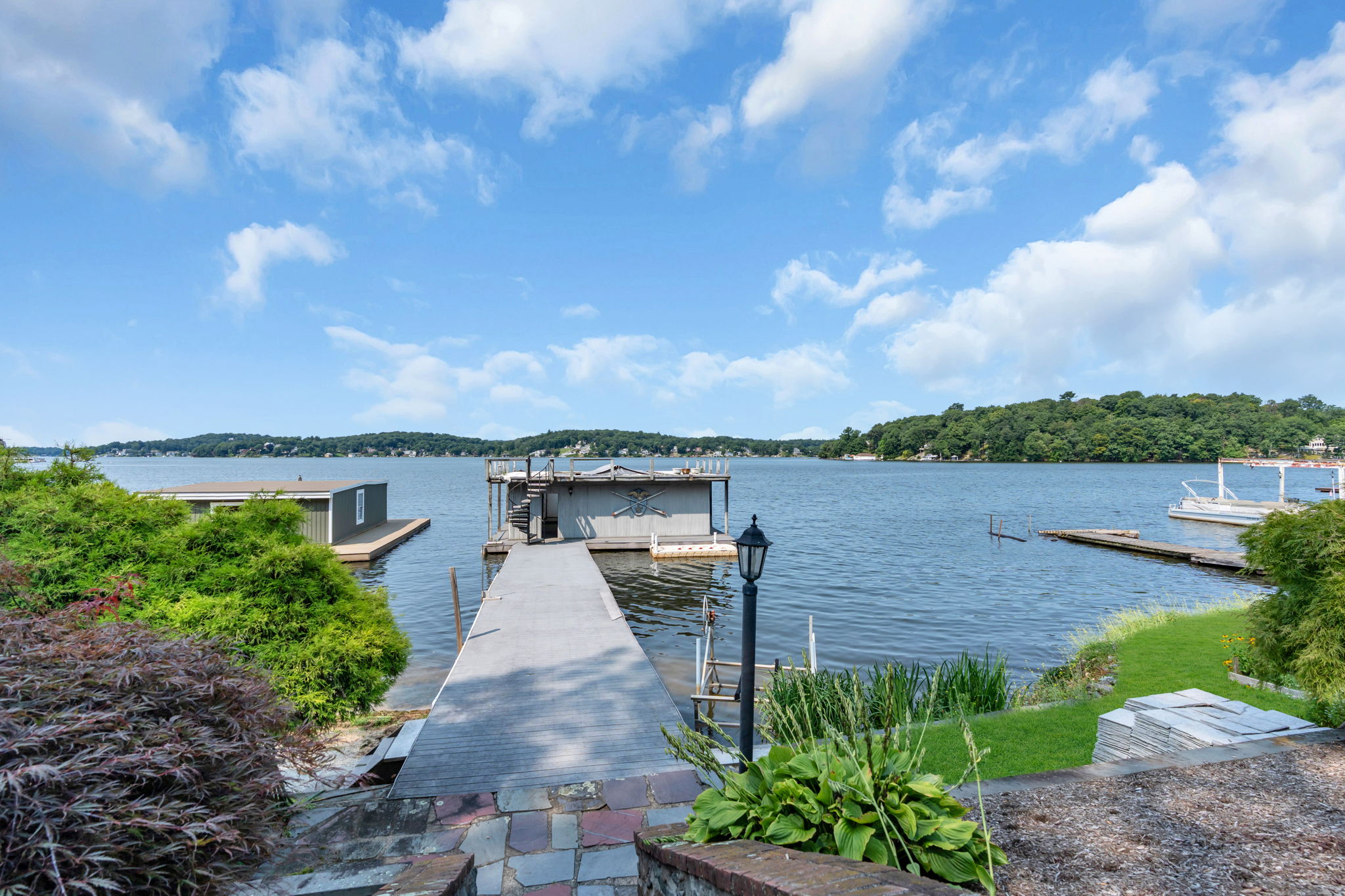 Composite decking leads to boat house with interior walk-around and storage