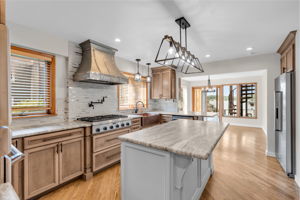 Hammered copper sink, stainless appliances, gas cooktop, professional range hood