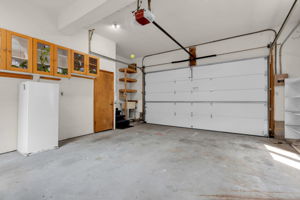 Two car garage with new insulated overhead motorized door and working utility sink, and entry to side yard as well as entry door to mud room off kitchen.