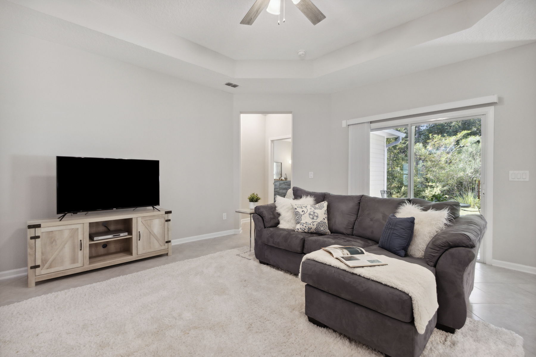 The living room overlooks a lush back yard ...