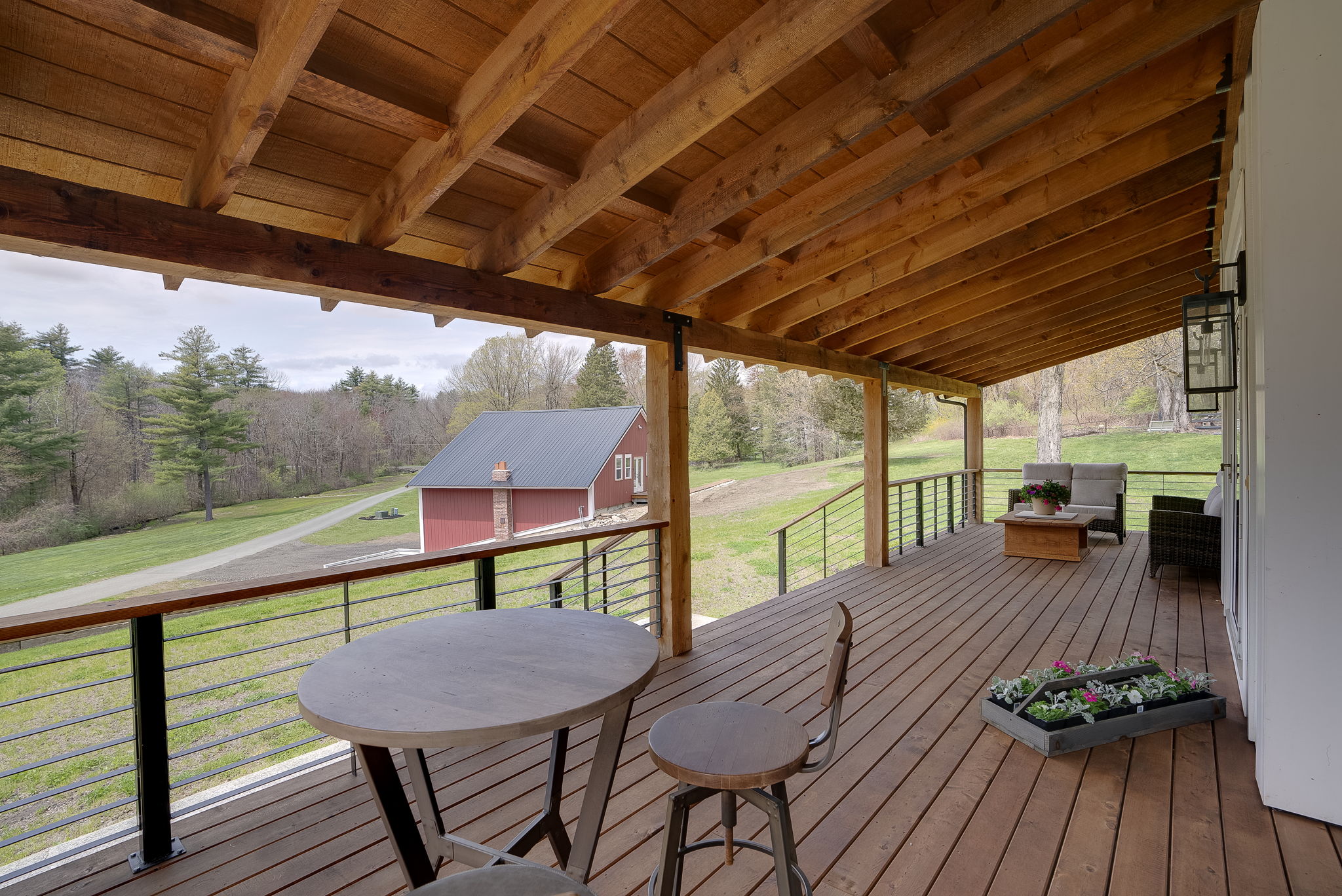 Expansive outdoor space designed for entertaining with views of the rustic barn and pond