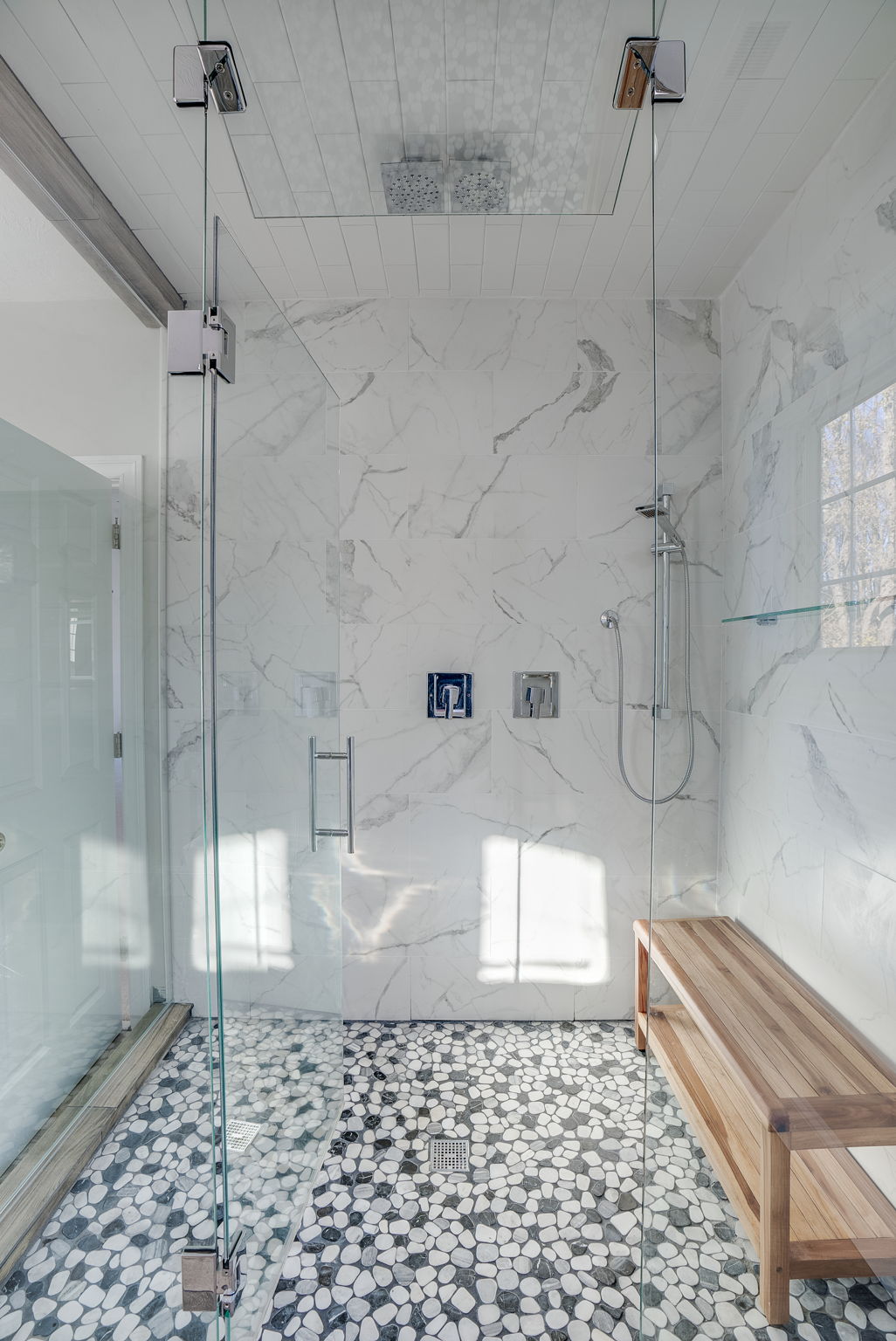 Walk-in steam shower, luxury shower head and fixtures, and natural stone floor
