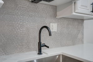 Detailed porcelain tile backsplash and Premium Kraus fixtures at the wet bar/coffe bar.