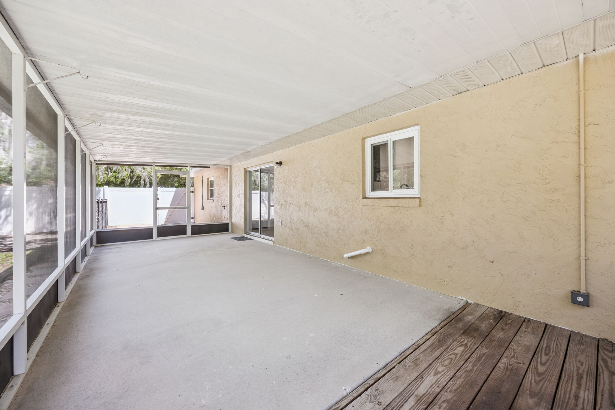 Large screened lanai with views of shaded backyard