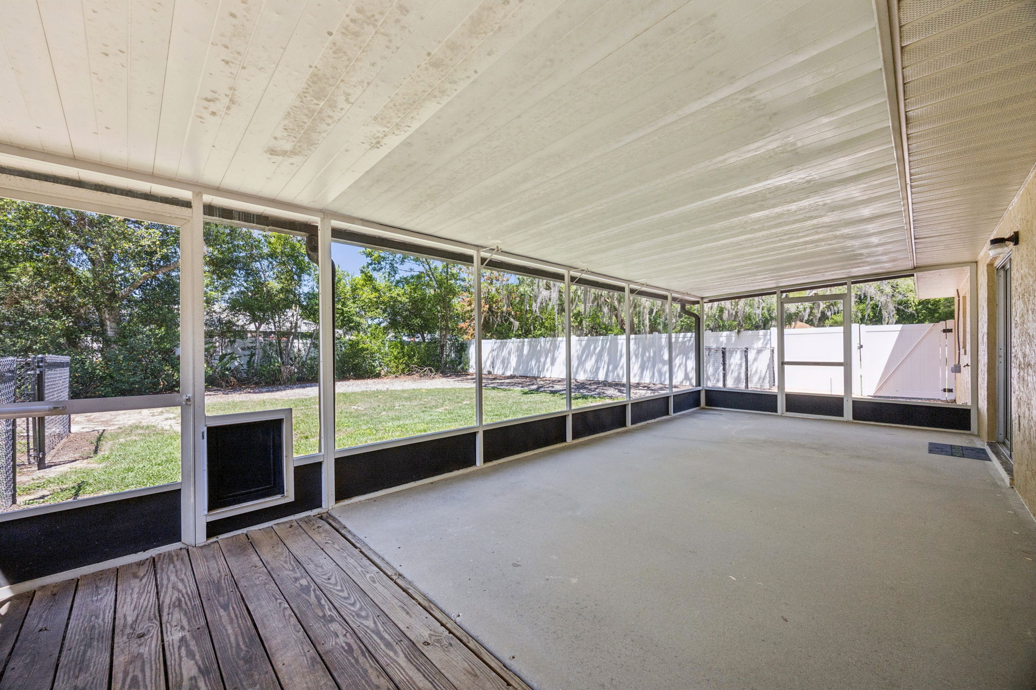 Large screened lanai with views of shaded backyard