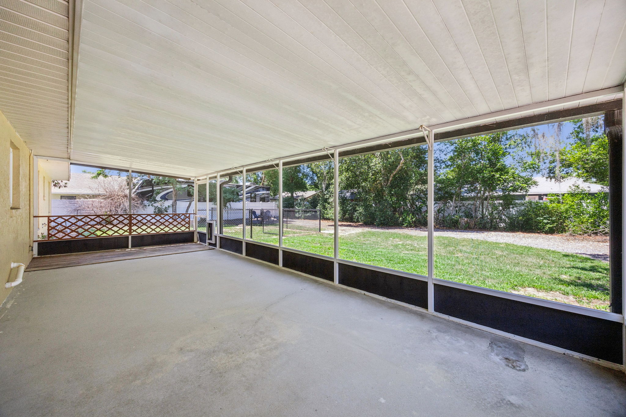 Large screened lanai with views of shaded backyard