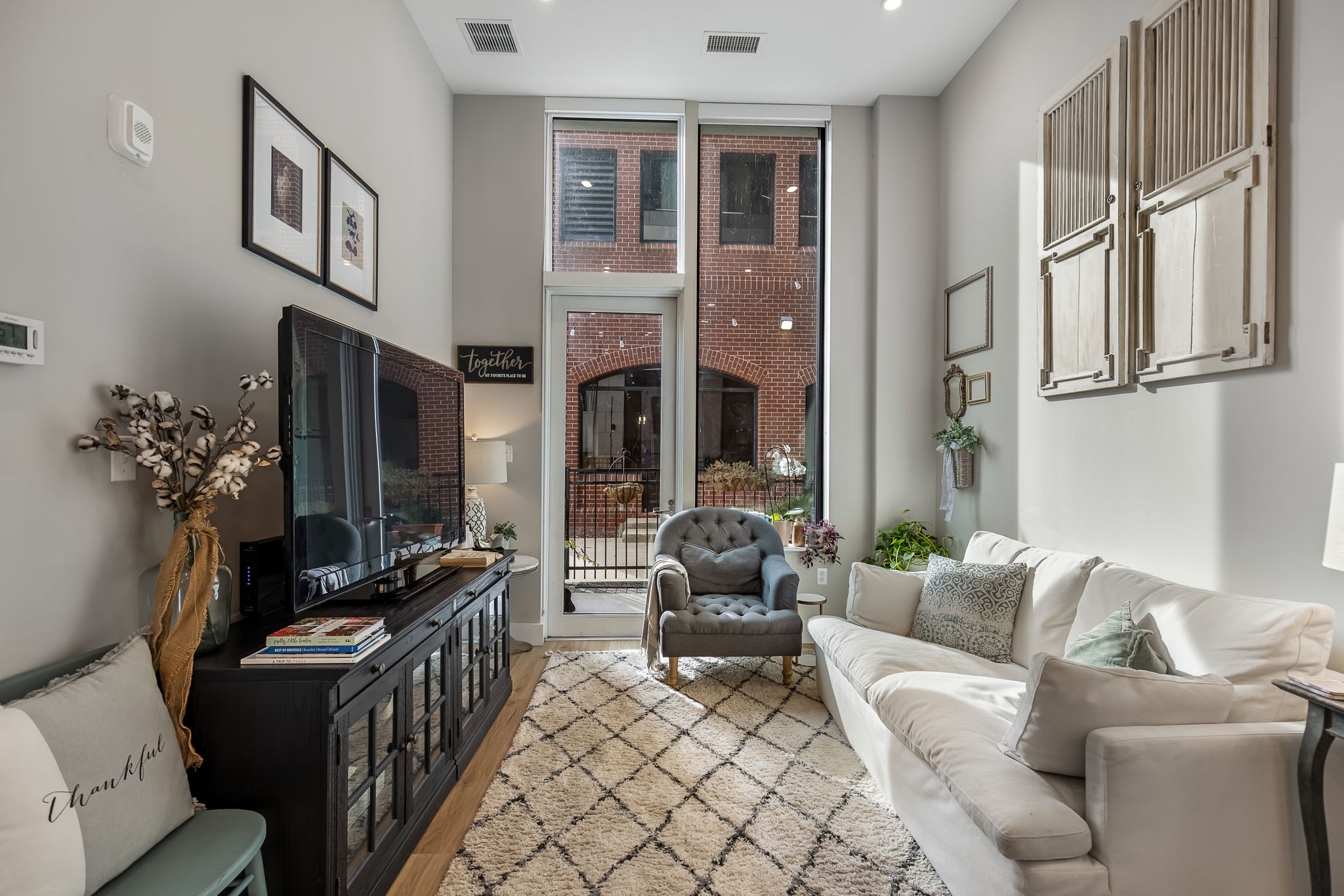Dramatic floor to ceiling Pella windows with custom blinds.