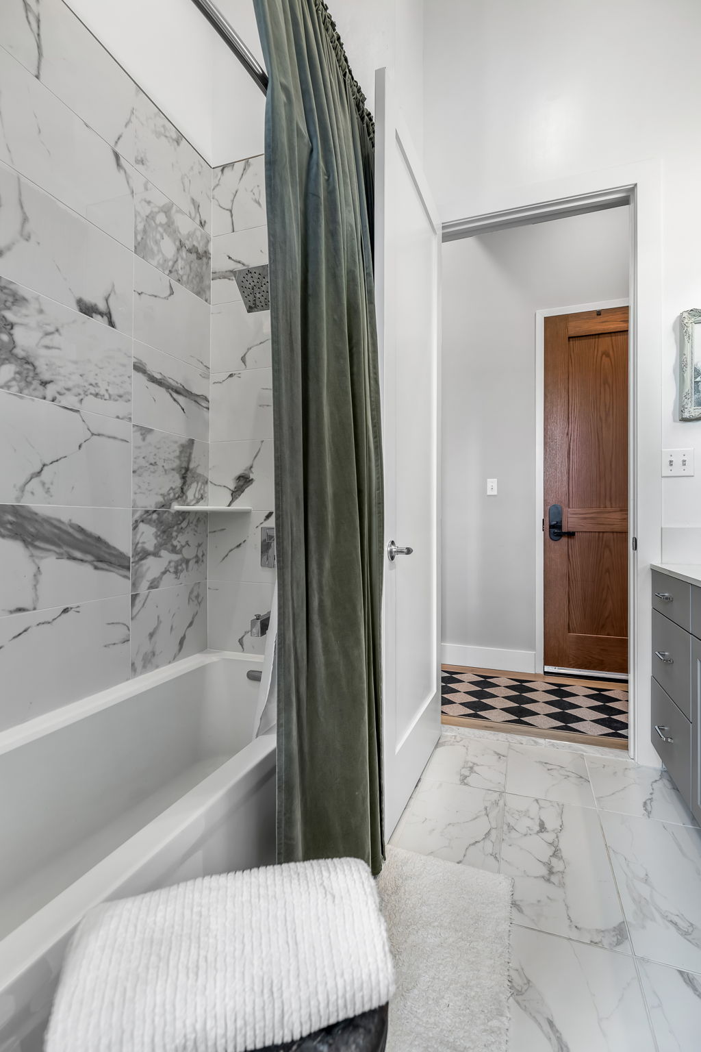 Sophisticated second full bathroom with a dual-entry layout, a relaxing shower and soaking tub combination, and beautiful limestone tile accents.