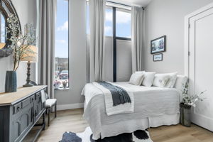 This elegant second bedroom offers ample space, designer draperies and blinds, a double closet, and dual-entry access to a full bathroom, combining comfort and functionality.