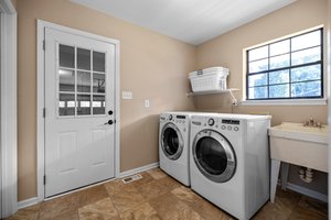 Laundry room with work sink and two closets