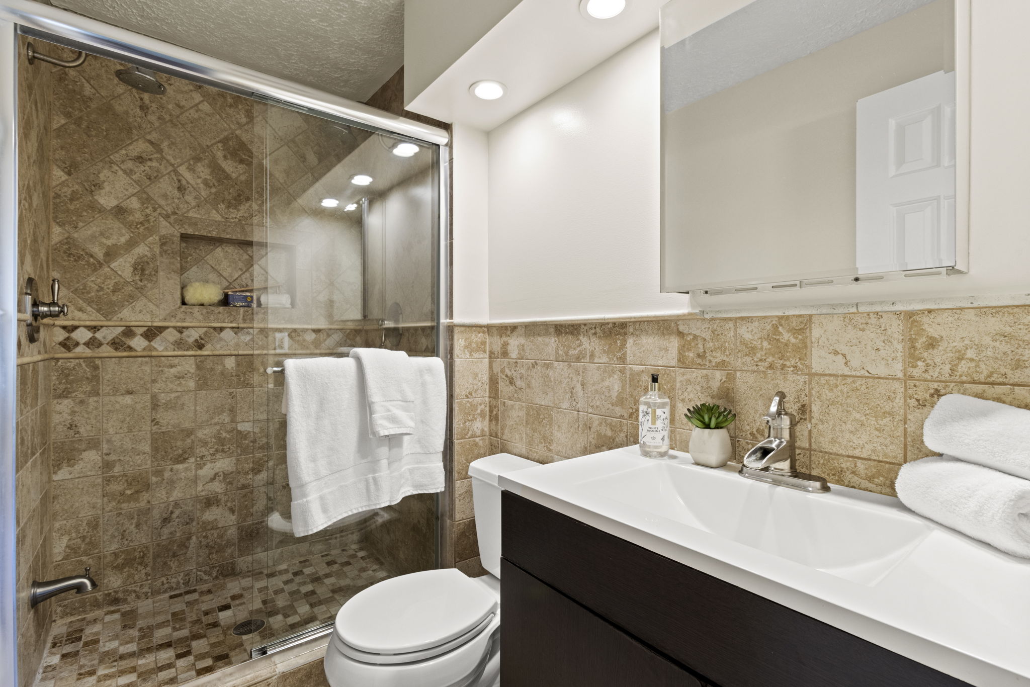 Primary Bathroom with dual shower heads and vaulted ceilings