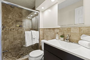 Primary Bathroom with dual shower heads and vaulted ceilings