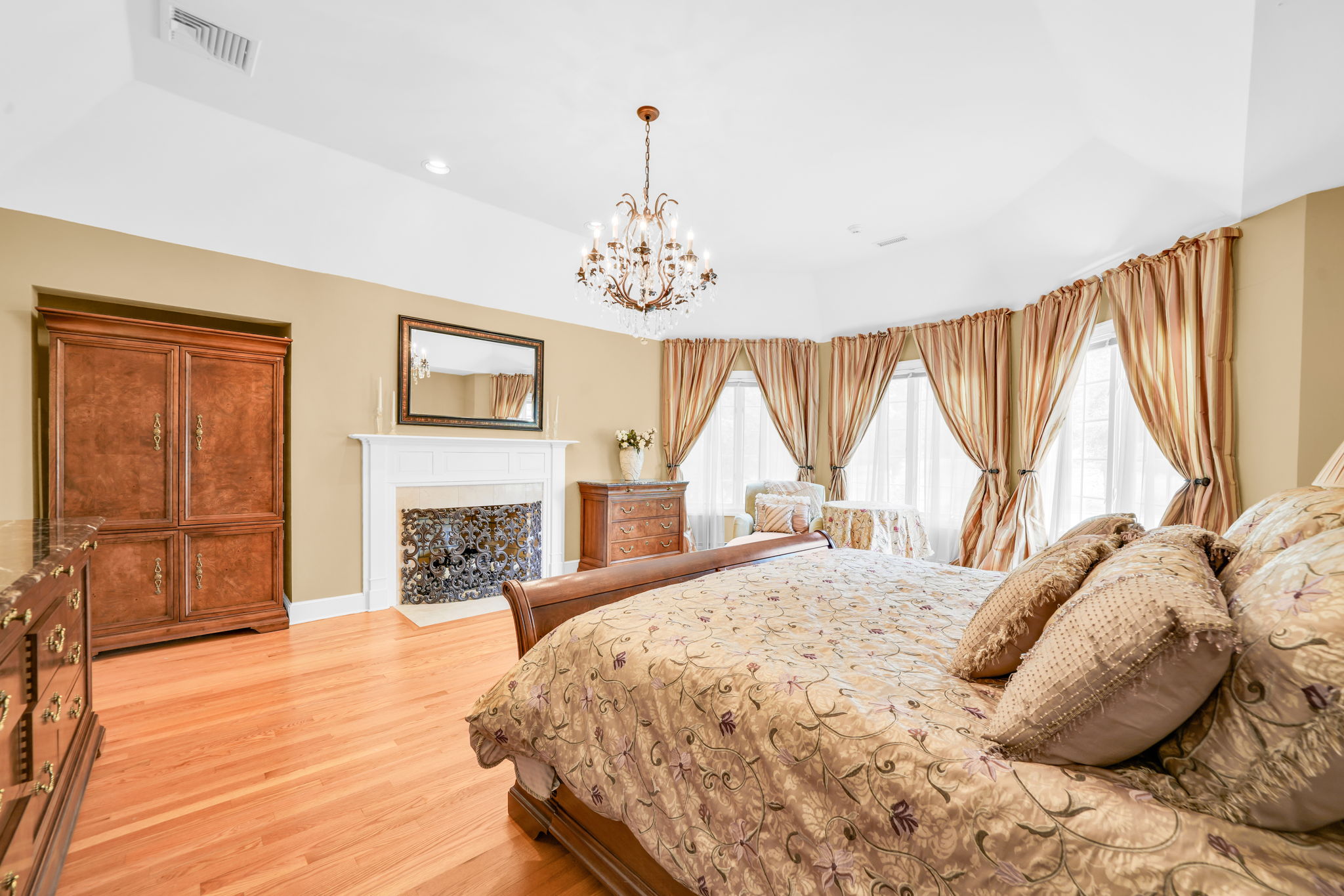 The primary suite, upstairs, is a retreat unto itself: a front bump-out adds architectural interest and extra square footage, while a walk-in closet plus a second closet handle wardrobe needs with ease. Its spa-style en-suite bath features in-floor heat, a walk-in shower, soaking tub, and bidet, along with its own fireplace, and a private sitting room or office with a balcony overlooks the sprawling backyard below.