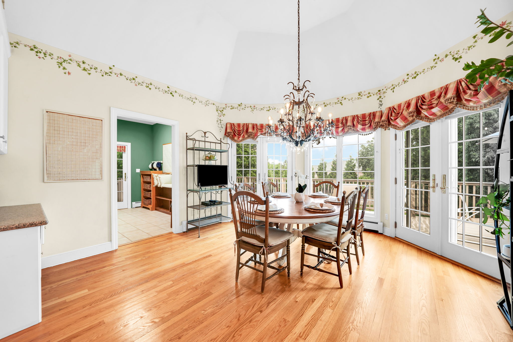 To the left, the kitchen: a bright, all-white showpiece with a large island for prepping or casual dining, an eat-in nook for everyday meals, a walk-in pantry, and a butler's pantry connecting seamlessly to the formal dining room. And just off the kitchen, in a detail only a homeowner who truly lived in the space would think to include, a second staircase with a wooden ladder rail, scaled for little hands and big hands alike, is tucked charmingly beside the everyday comings and goings of family life.