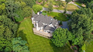 The approach alone tells you what you're in for. A circular driveway, anchored by a paver walkway at its center, sweeps past manicured grounds toward an oversized three-car garage and an entrance built for arrival, framed by brick on three sides of the home's exterior.