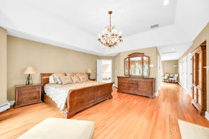 The primary suite, upstairs, is a retreat unto itself: a front bump-out adds architectural interest and extra square footage, while a walk-in closet plus a second closet handle wardrobe needs with ease. Its spa-style en-suite bath features in-floor heat, a walk-in shower, soaking tub, and bidet, along with its own fireplace, and a private sitting room or office with a balcony overlooks the sprawling backyard below.