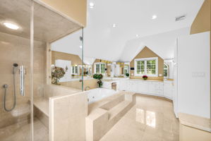The primary suite, upstairs, is a retreat unto itself: a front bump-out adds architectural interest and extra square footage, while a walk-in closet plus a second closet handle wardrobe needs with ease. Its spa-style en-suite bath features in-floor heat, a walk-in shower, soaking tub, and bidet, along with its own fireplace, and a private sitting room or office with a balcony overlooks the sprawling backyard below.