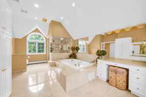 The primary suite, upstairs, is a retreat unto itself: a front bump-out adds architectural interest and extra square footage, while a walk-in closet plus a second closet handle wardrobe needs with ease. Its spa-style en-suite bath features in-floor heat, a walk-in shower, soaking tub, and bidet, along with its own fireplace, and a private sitting room or office with a balcony overlooks the sprawling backyard below.