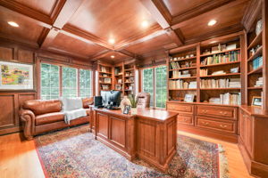 Nearby, a custom, fully cherry-trimmed study with a coffered wood ceiling and a custom desk offers a work-from-home space that feels like it belongs in a private club.