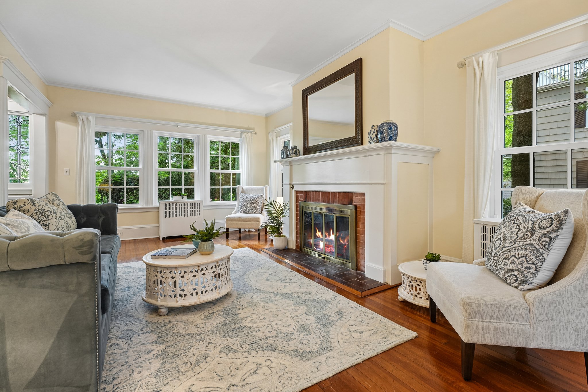 Wrapped in windows and leafy views, this inviting living room has a quiet, tucked-away feeling that makes it hard to believe Manhattan is only about 20 miles away. More retreat than suburb, it’s a space that invites deep breaths, slow mornings, and evenings by the fire as the trees sway just beyond the glass.
