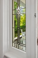 Handcrafted leaded glass, and sunlight filtering through the trees — a timeless welcome to this hilltop Caldwell classic.