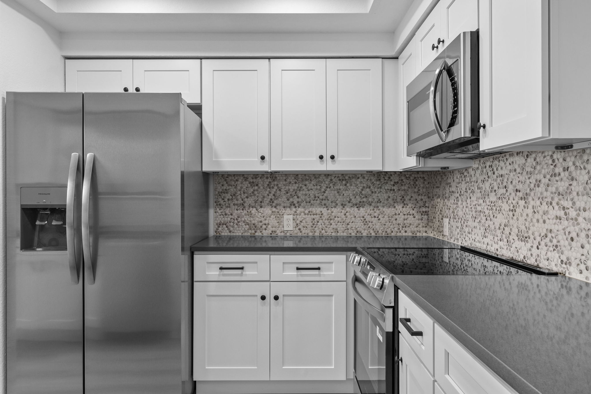 Newly updated with new white shaker cabinets and hardware, new appliances, sink & faucet, gray quartz countertops and backsplash.